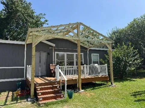 Pergola-covered deck and steps built by Kingdom Services onto a manufactured home