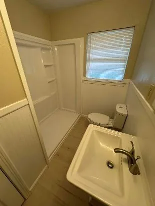 Remodeled bathroom with new shower surround, vanity and wainscot