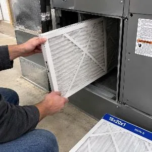 Changing an HVAC air filter during a maintenance visit